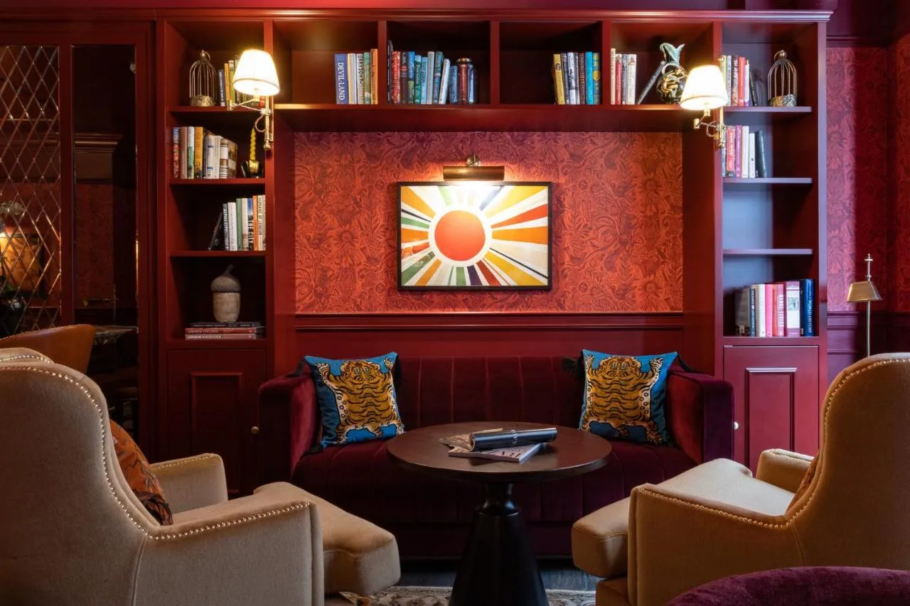 a room with chairs and a table and bookshelves at Sun Street Hotel Shoreditch in London