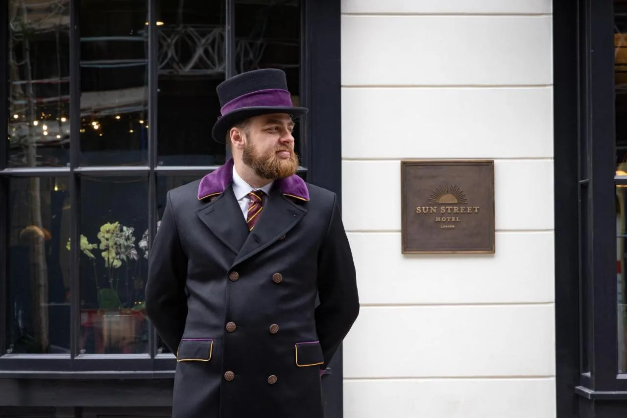 a man in a top hat standing in front of a building at Sun Street Hotel Shoreditch in London