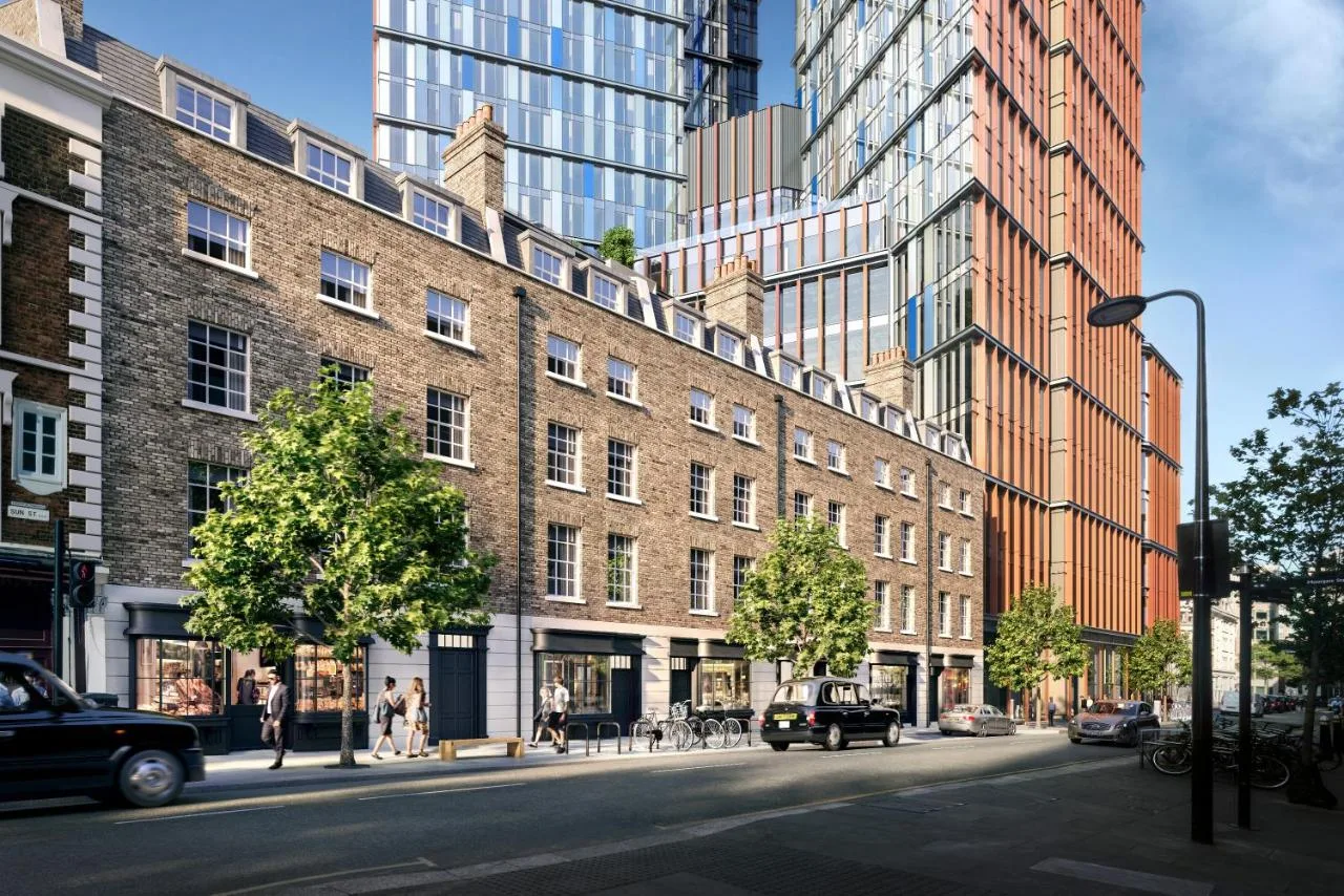 a large brick building on a city street with tall buildings at Sun Street Hotel Shoreditch in London